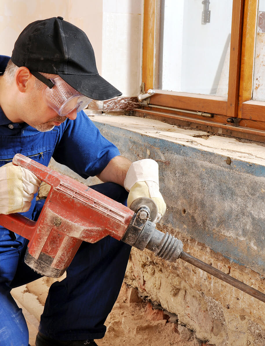 Handwerker führt Arbeiten mit einem Bohrmeissel durch